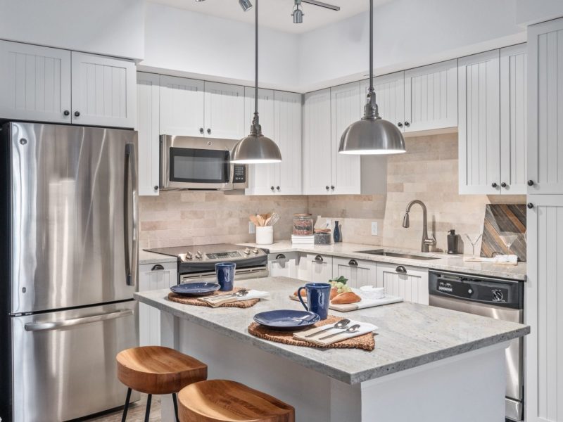 This image shows the Premium Apartment Feature, especially the kitchen island showcasing a granite-inspired countertop, a neat design, and accessible area through the bathroom.